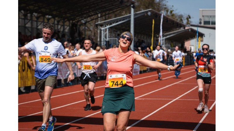 Kobiety i mężczyźni bignący na stadionie miejskim podczas zawodów biegowych